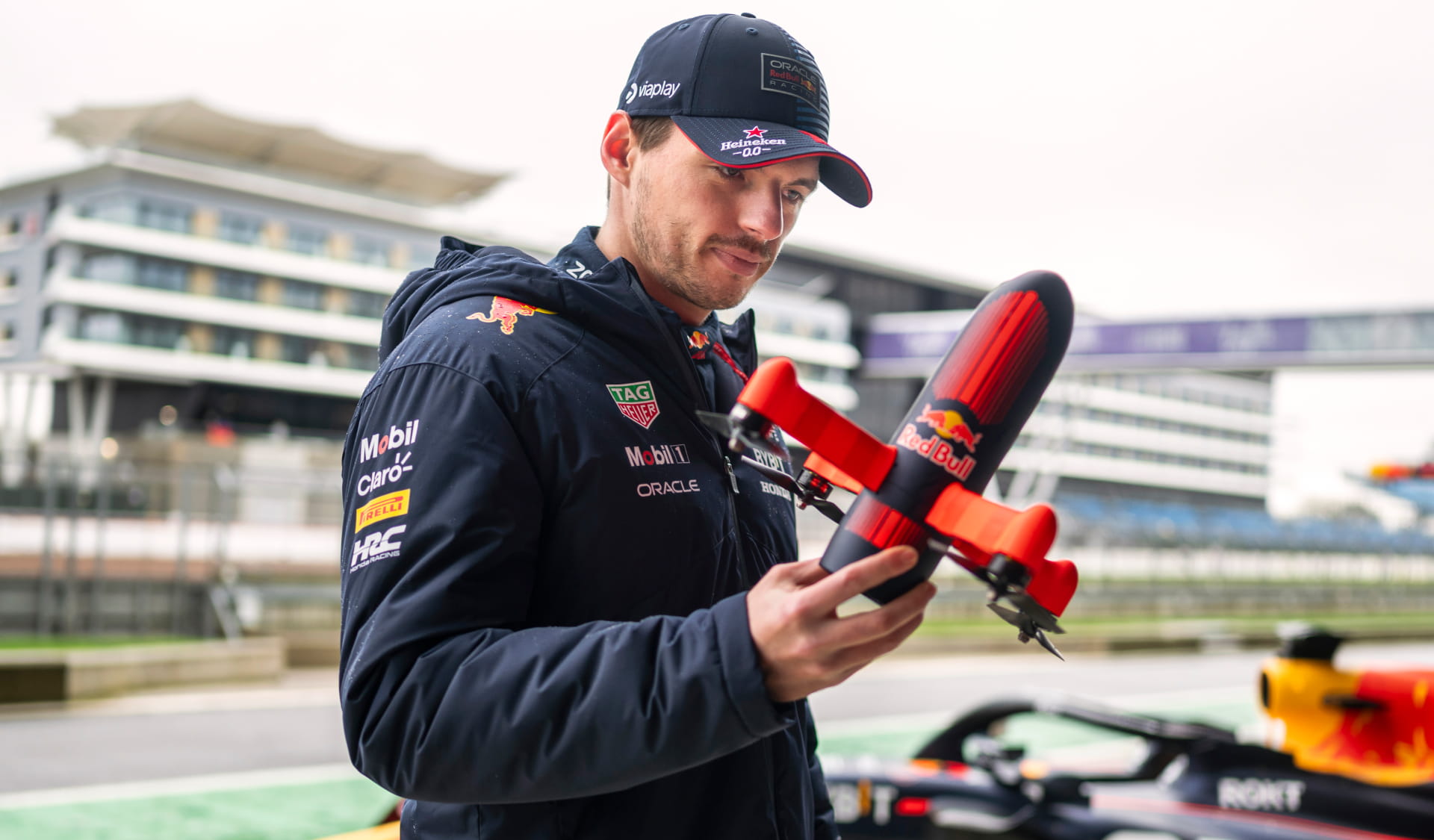 Max Verstappen holding a Red Bull drone in his hand