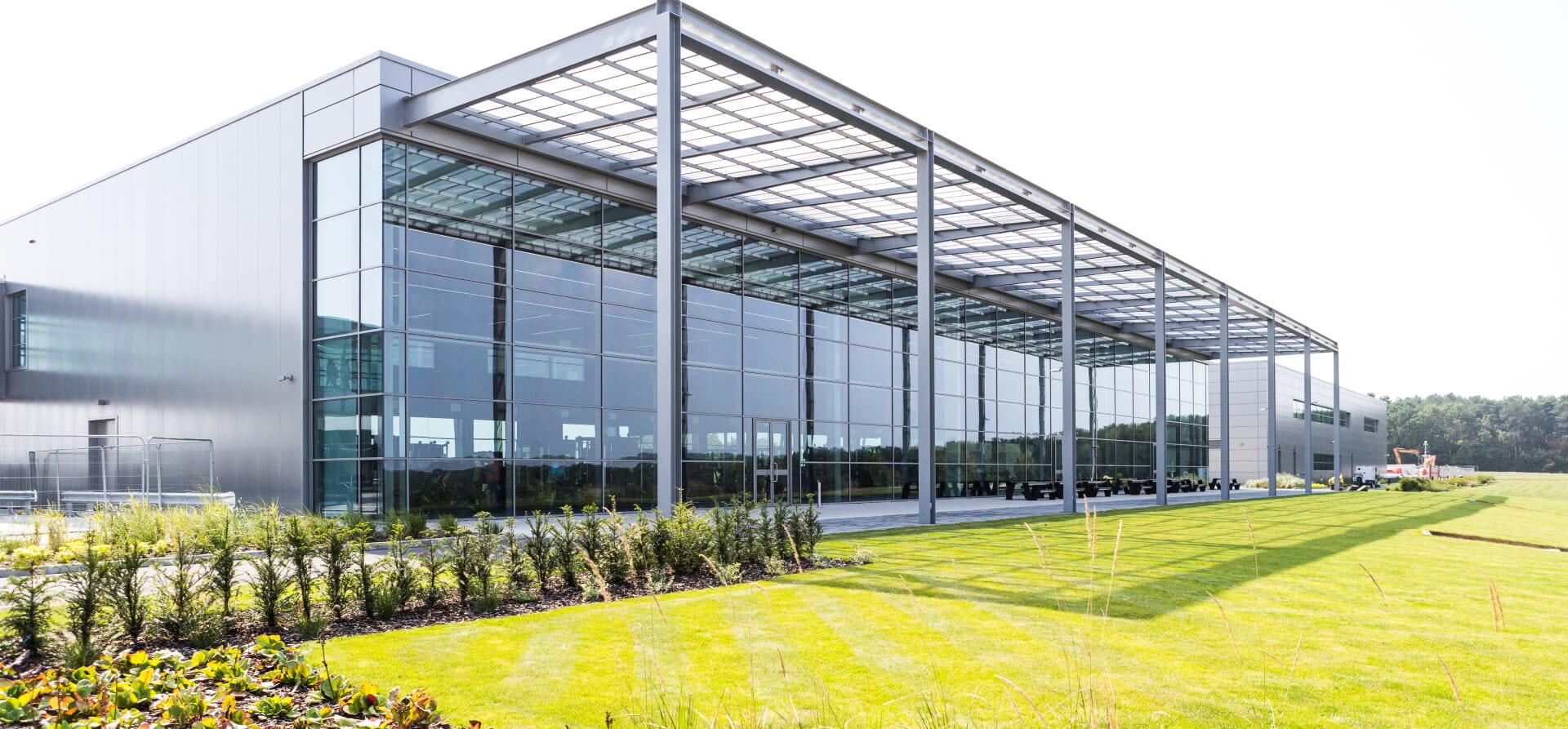 Glass panelled building from the outside in well-lit conditions with green grass on the outside