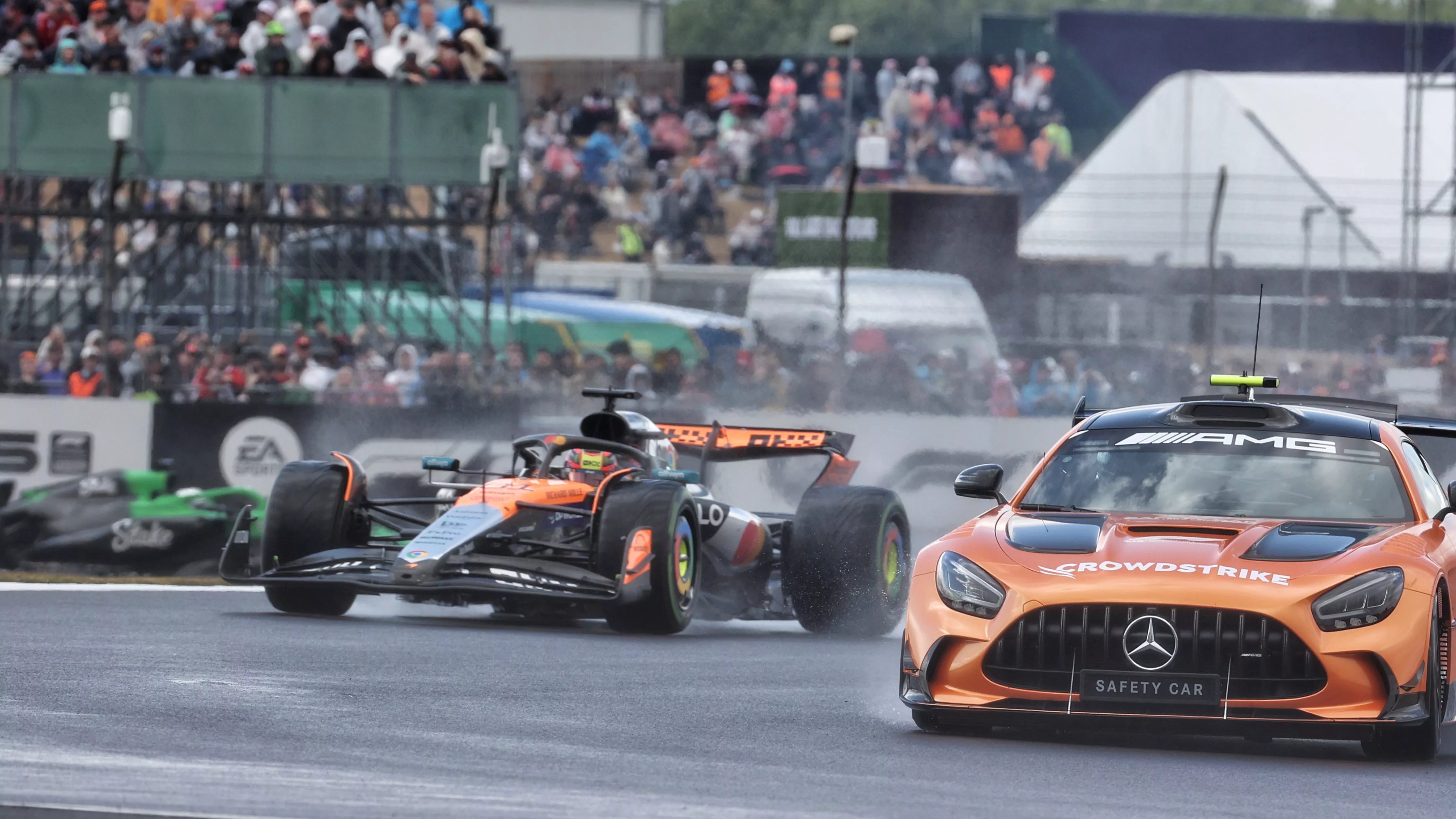 McLaren F1 car in rain behind safety car